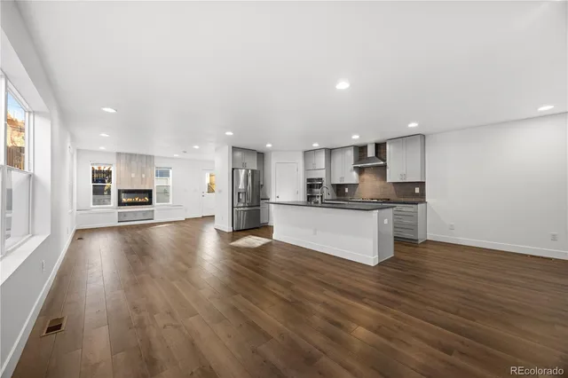 a view of kitchen with cabinets stainless steel appliances and wooden floor