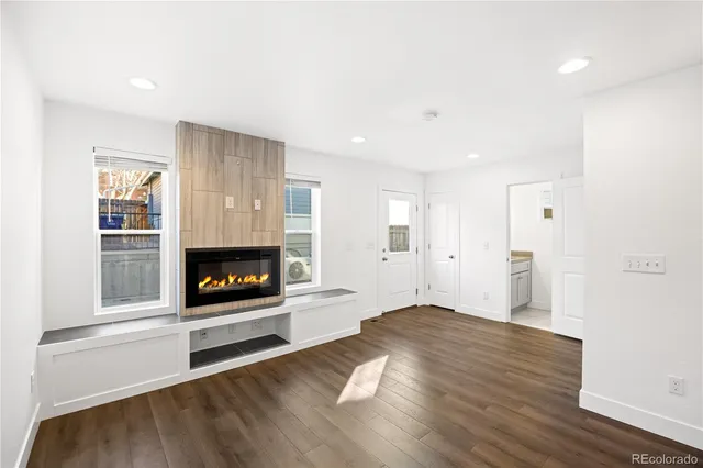 a view of a livingroom with a fireplace wooden floor and window