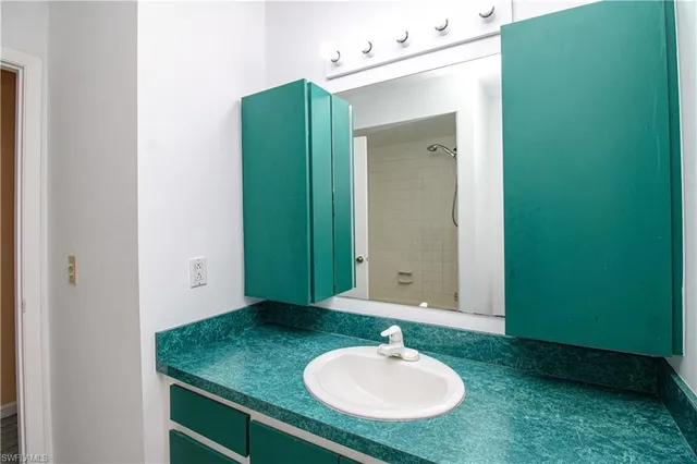 a bathroom with a granite countertop sink and a bathtub