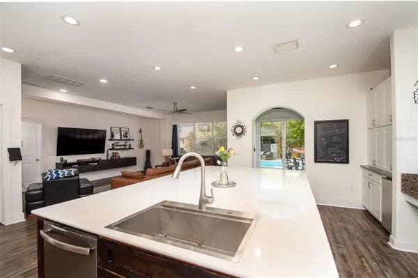 a kitchen with granite countertop white cabinets white stainless steel appliances and sink
