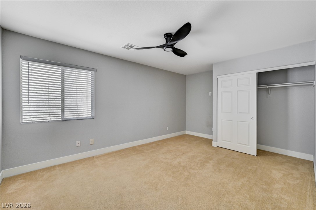 7259 Cestrum Road Las Vegas, NV 89113 - Photo 19 of 35 A well-lit bedroom with soft carpeting and a modern ceiling fan for comfort.