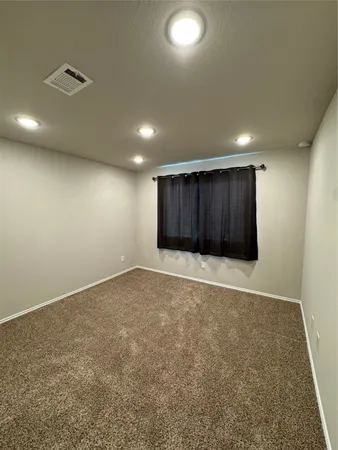 an empty room with a cabinet and mirrors