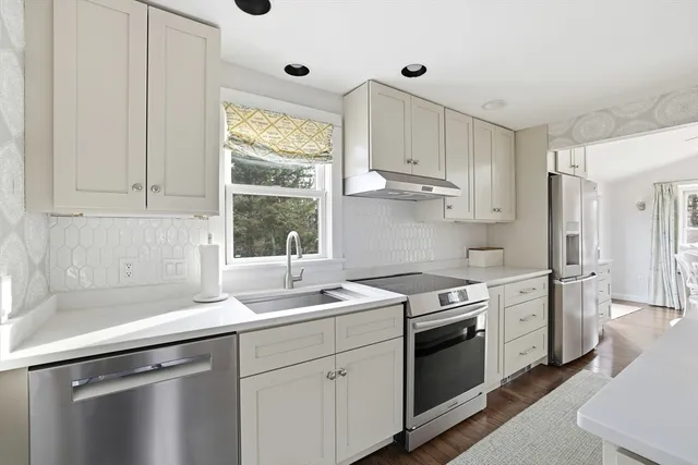 a kitchen with stainless steel appliances granite countertop a sink stove and cabinets