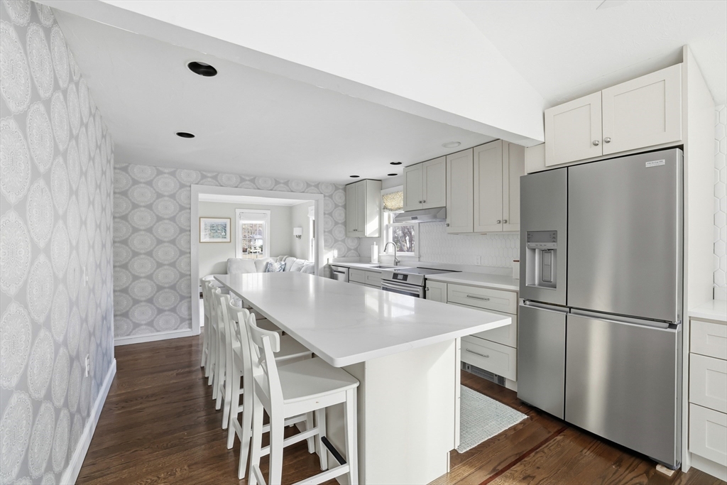73 Shingle Mill Lane Hanover, MA 02339 - Photo 7 of 23 a kitchen with stainless steel appliances a refrigerator a sink a stove a dining table and chairs