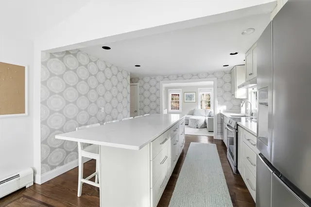 a kitchen with a wooden floor and white cabinets