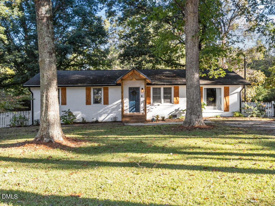9433 Ferrell Road Zebulon, NC 27597 - Photo 31 of 38 a front view of a house with a garden and trees