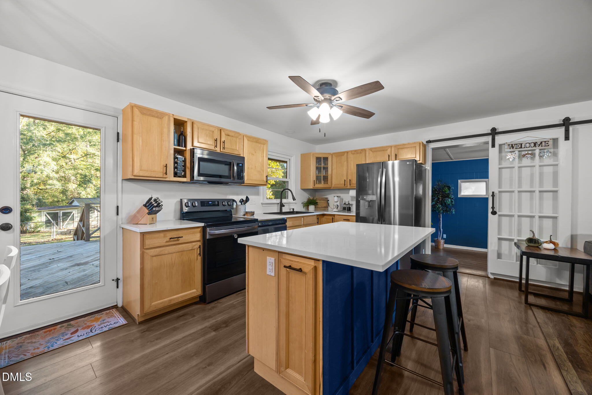 9433 Ferrell Road Zebulon, NC 27597 - Photo 9 of 38 a kitchen with a stove a sink dishwasher a refrigerator with a dining table and chairs with wooden floor