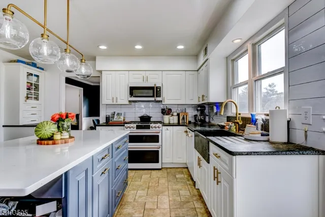 a kitchen with stainless steel appliances a sink dishwasher a refrigerator a stove top oven a sink and dishwasher
