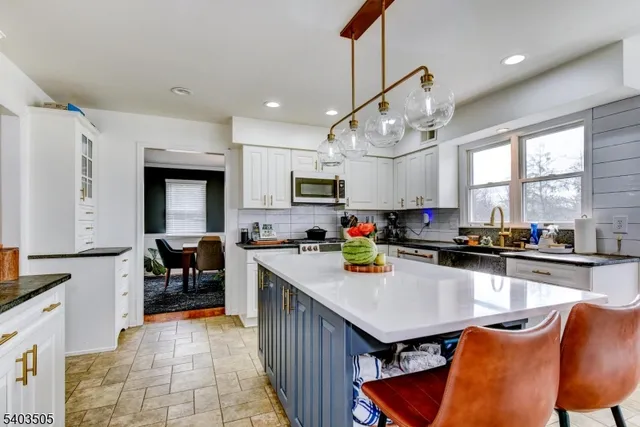 a kitchen with a table chairs microwave and cabinets