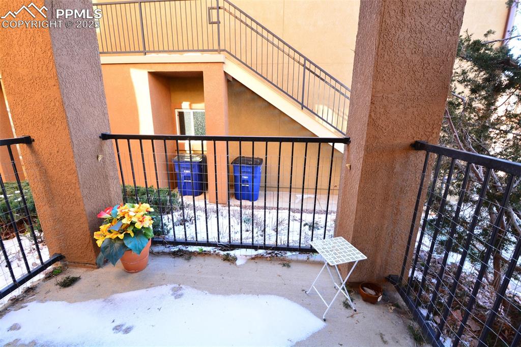 6967 Stetson Ranch Point, Unit 105 Colorado Springs, CO 80922 - Photo 12 of 37 a view of a balcony with chair and wooden floor