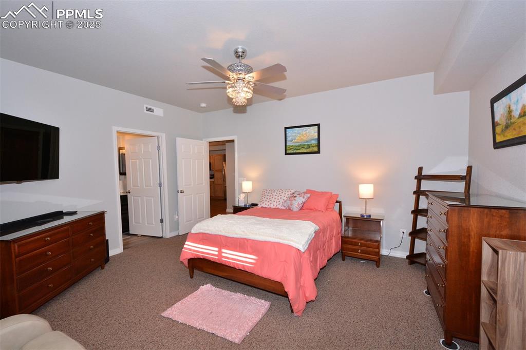 6967 Stetson Ranch Point, Unit 105 Colorado Springs, CO 80922 - Photo 13 of 37 a bedroom with a bed and a flat screen tv