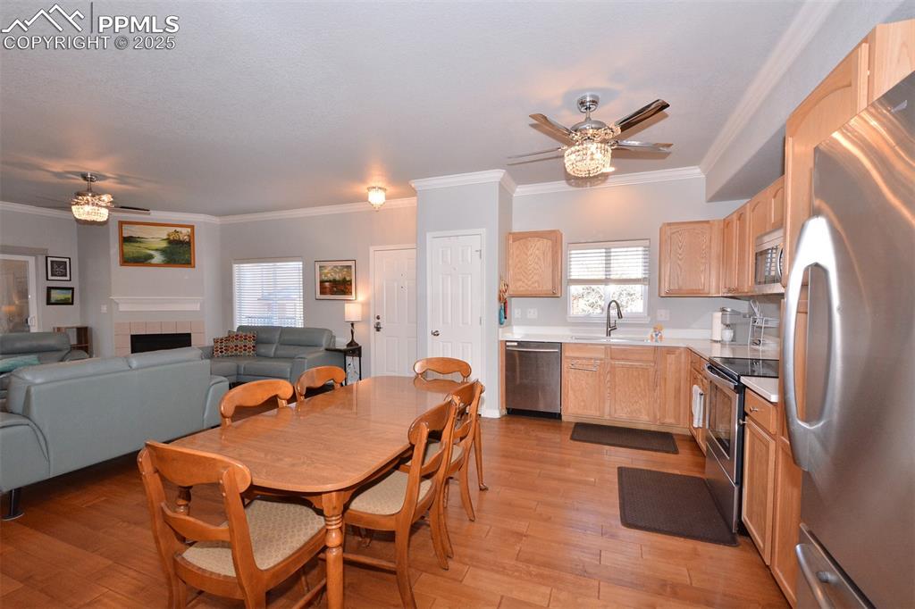 6967 Stetson Ranch Point, Unit 105 Colorado Springs, CO 80922 - Photo 5 of 37 a kitchen with stainless steel appliances a table chairs and a refrigerator