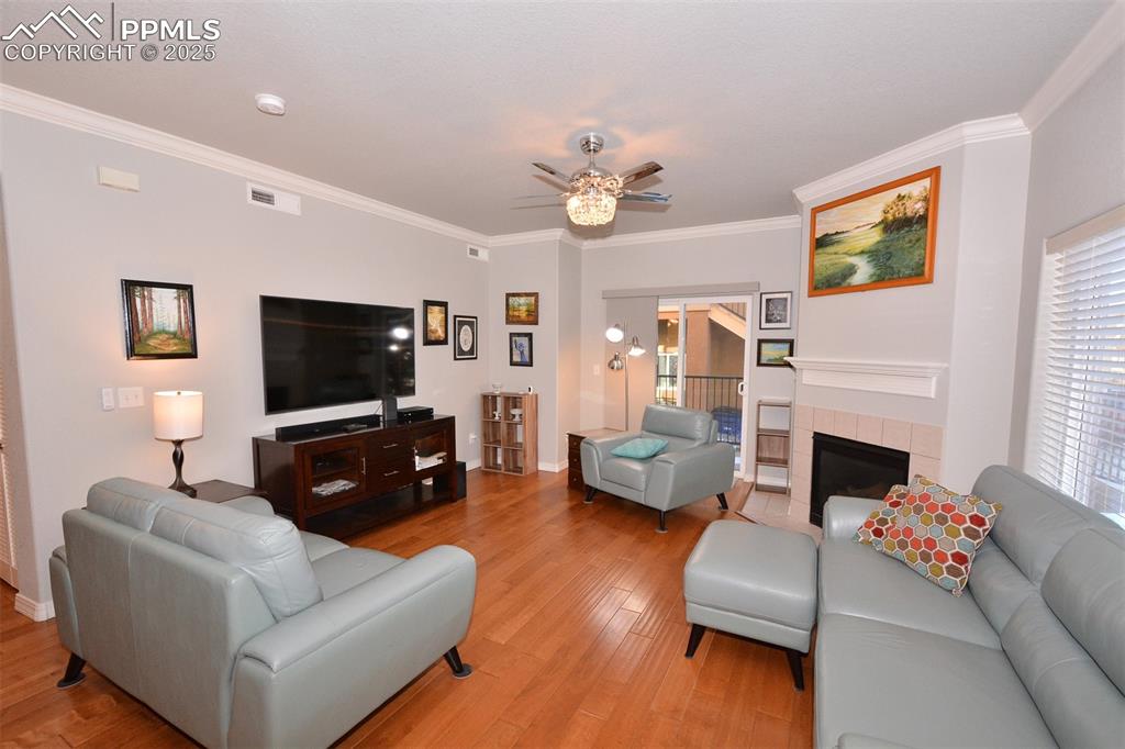 6967 Stetson Ranch Point, Unit 105 Colorado Springs, CO 80922 - Photo 9 of 37 a living room with furniture a fireplace and a flat screen tv