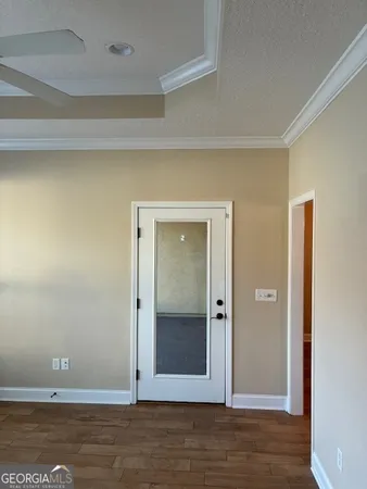 an empty room with wooden floor and door
