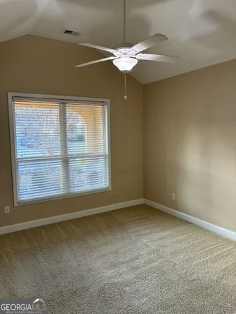 en empty room with window and ceiling fan