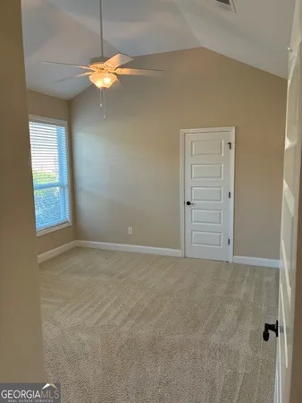 an empty room and a chandelier fan