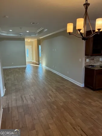 a view of a room with wooden floor and flat screen tv
