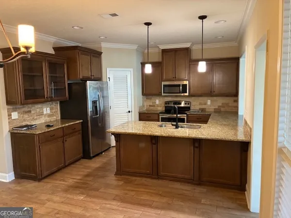 a kitchen with stainless steel appliances granite countertop a sink refrigerator and cabinets
