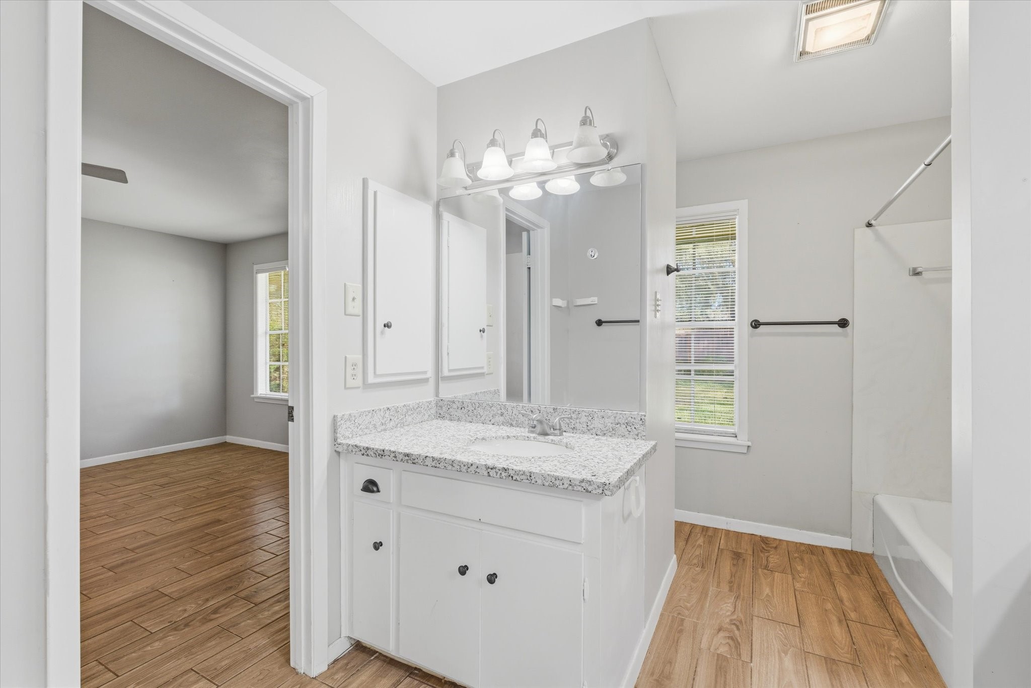 6004 Lakeside Drive Liberty, TX 77575 - Photo 18 of 28 a bathroom with a granite countertop sink a mirror and a shower