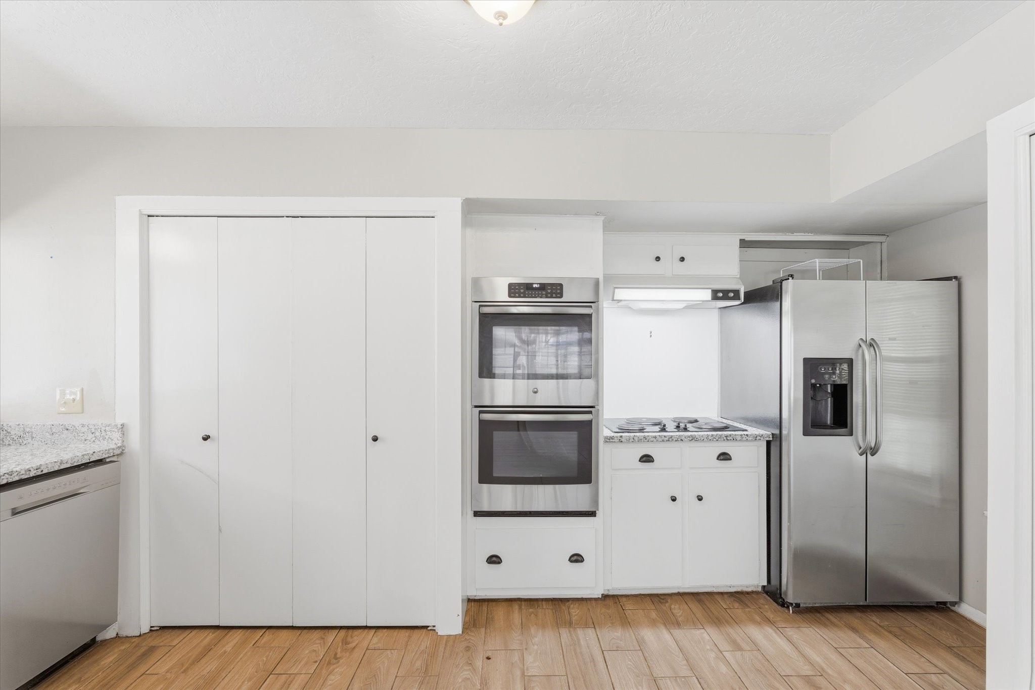 6004 Lakeside Drive Liberty, TX 77575 - Photo 6 of 28 a kitchen with cabinets and white stainless steel appliances