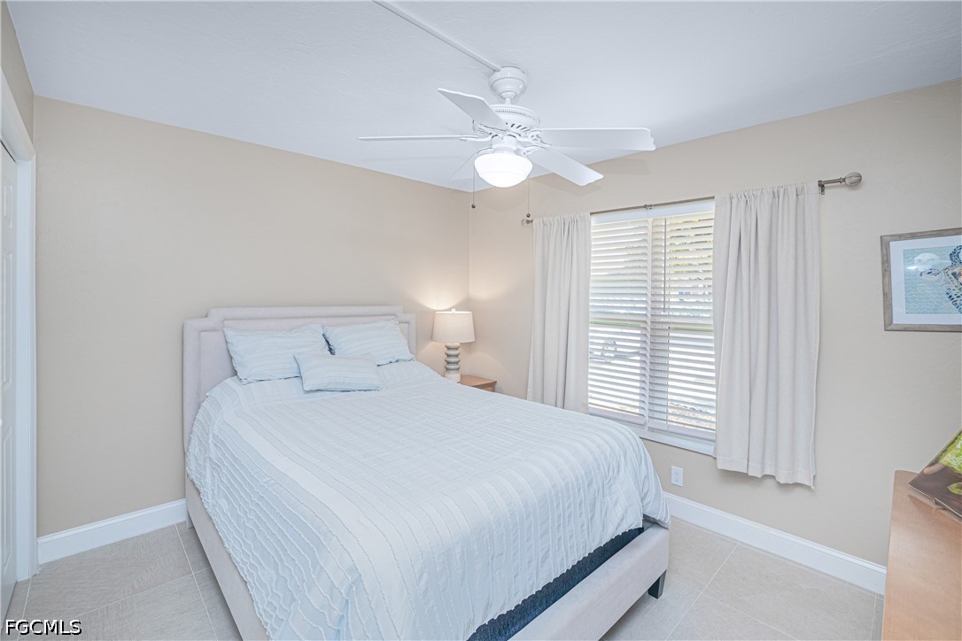 16007 Davis Road, Unit 713 Fort Myers, FL 33908 - Photo 16 of 41 a bedroom with a large bed and a chandelier