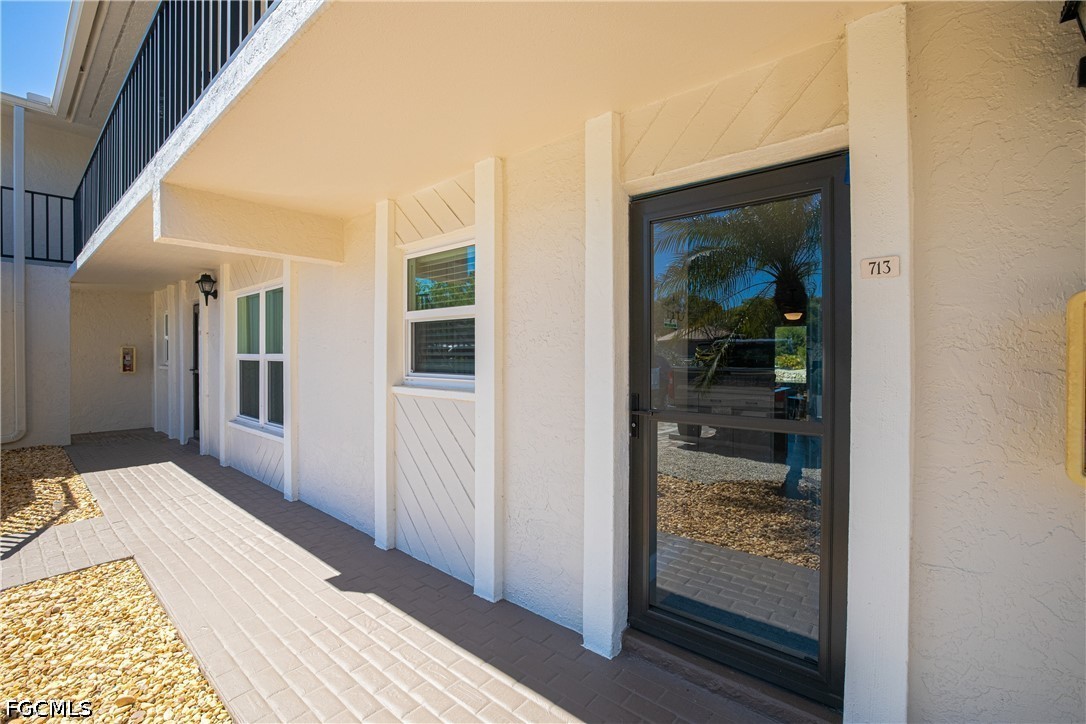 16007 Davis Road, Unit 713 Fort Myers, FL 33908 - Photo 2 of 41 a view of a hallway with wooden floor and a bathroom
