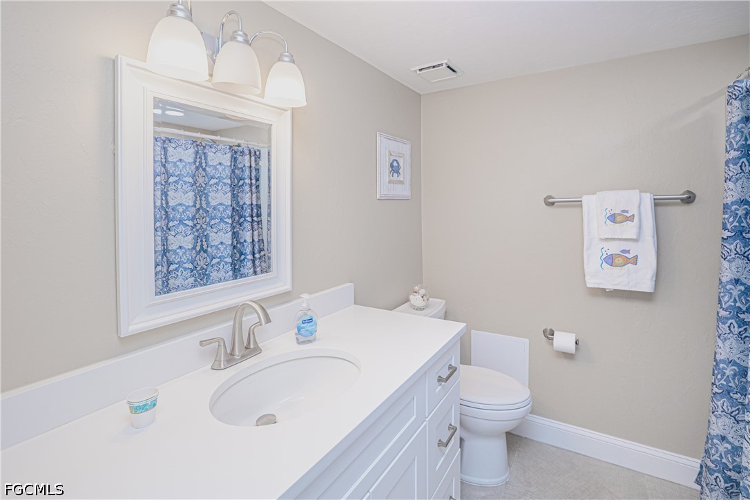 16007 Davis Road, Unit 713 Fort Myers, FL 33908 - Photo 22 of 41 a bathroom with a sink a toilet and a mirror