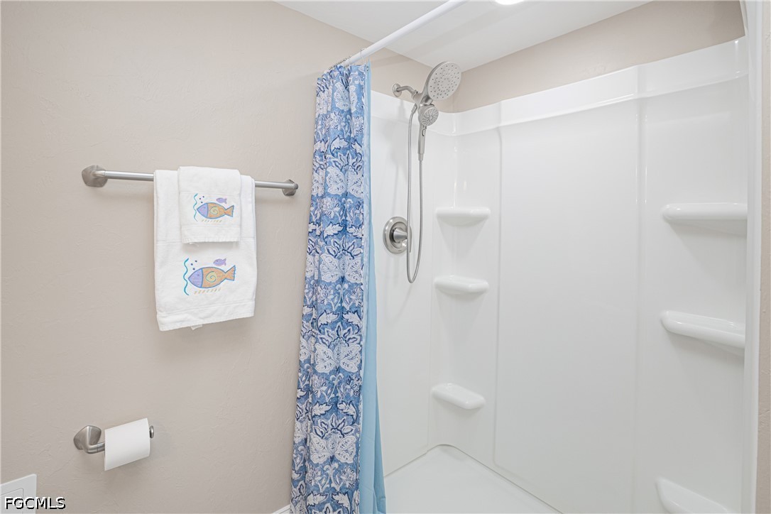 16007 Davis Road, Unit 713 Fort Myers, FL 33908 - Photo 25 of 41 a bathroom with a shower curtain and a shower curtain