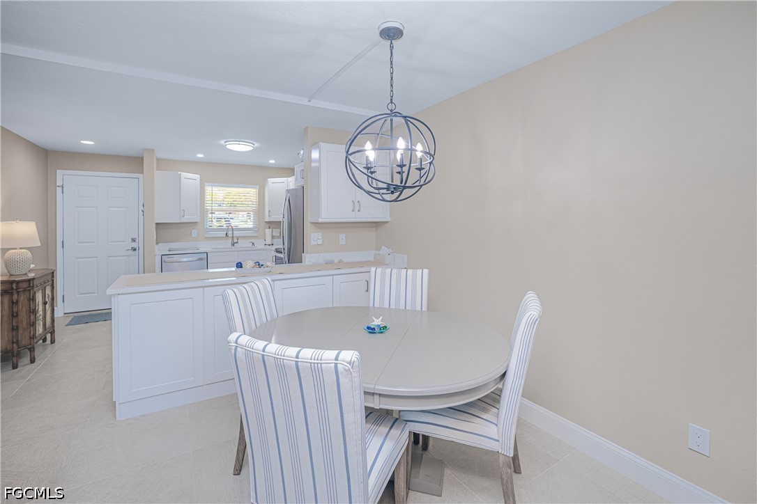 16007 Davis Road, Unit 713 Fort Myers, FL 33908 - Photo 9 of 41 a view of a dining room with furniture a chandelier and wooden floor