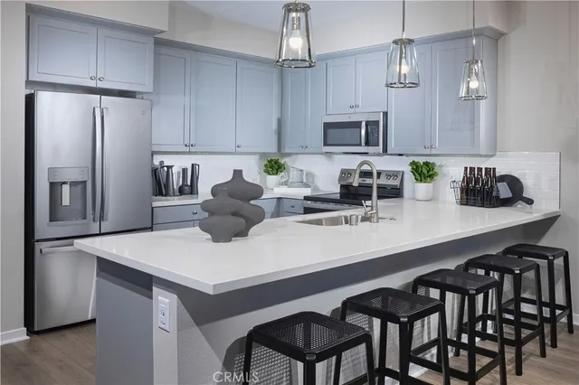 a kitchen with a sink a refrigerator and chairs