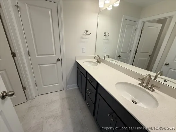 a bathroom with a double vanity sink and a mirror