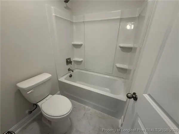 a white toilet sitting next to a bath tub
