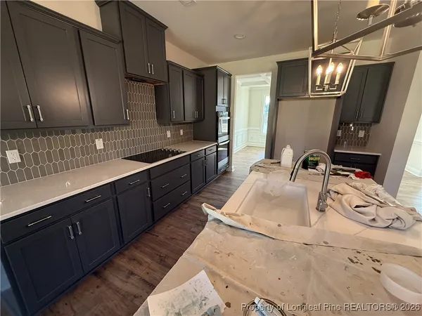a kitchen with stainless steel appliances sink a stove and cabinets