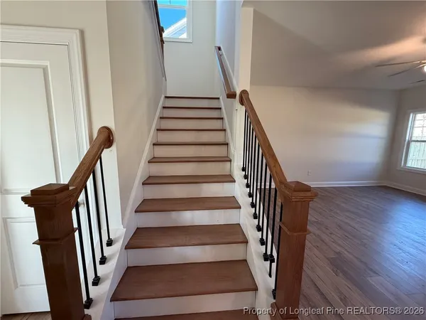 a view of staircase with wooden floor and white walls