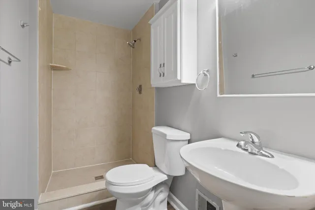 a bathroom with a sink a toilet and a mirror