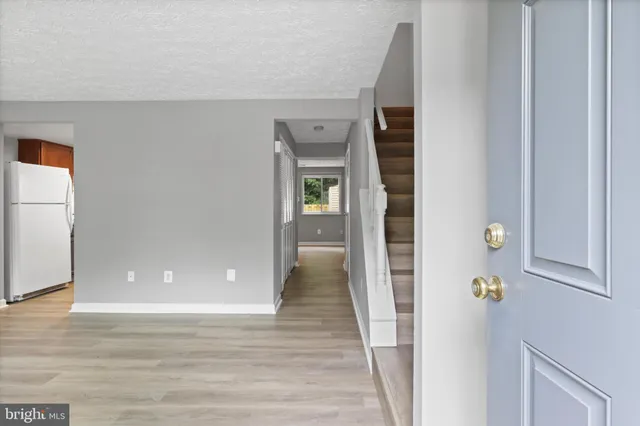 a view of a hallway with wooden floor and closet