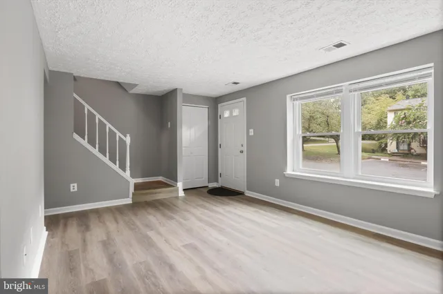 a view of an empty room with glass door and balcony