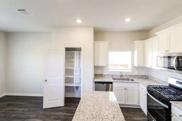 a kitchen with granite countertop a sink cabinets and window