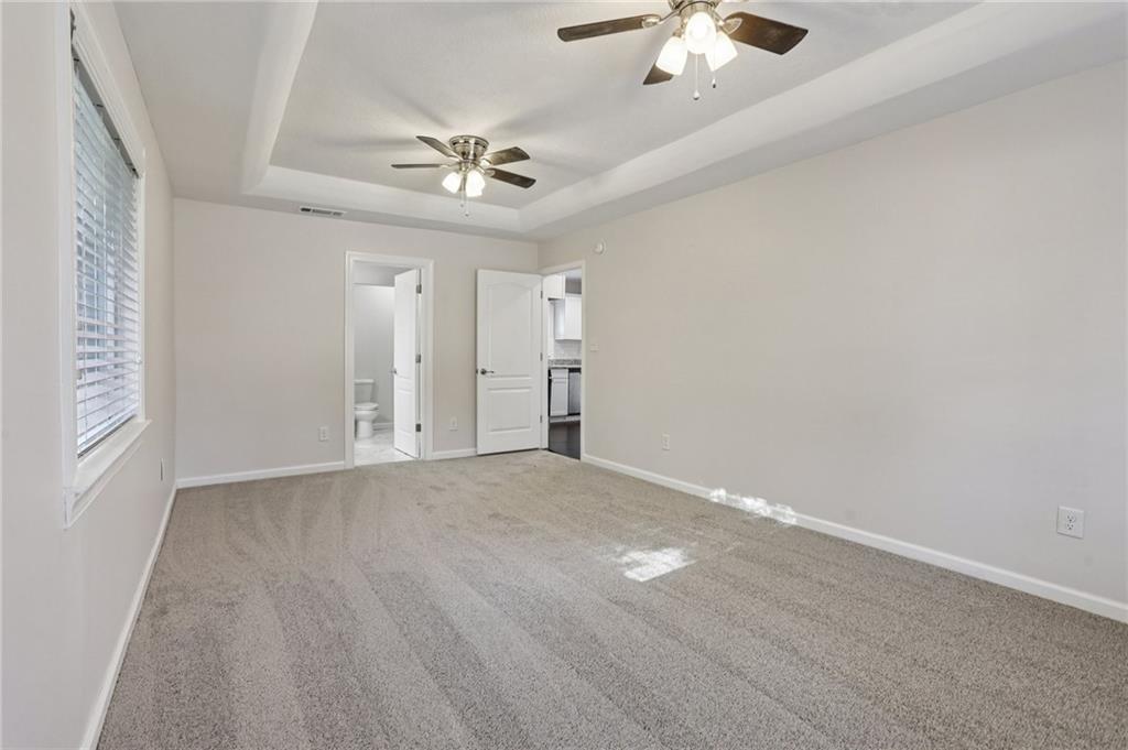 4938 White Boulevard Southwest Mableton, GA 30126 - Photo 21 of 39 an empty room with a chandelier fan and windows