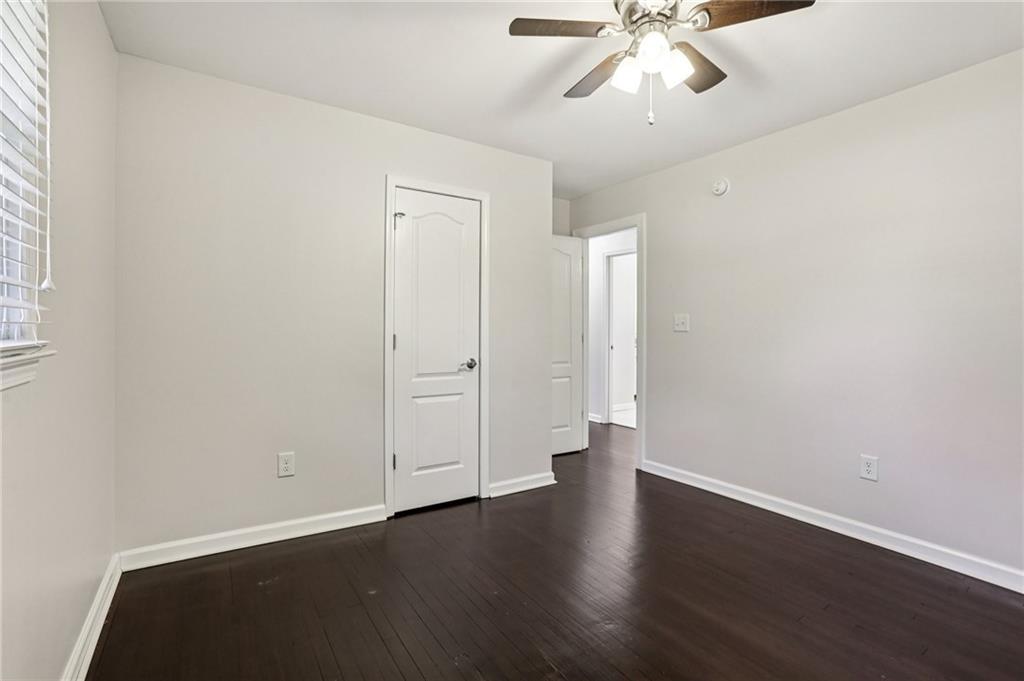 4938 White Boulevard Southwest Mableton, GA 30126 - Photo 31 of 39 an empty room with wooden floor chandelier fan and windows