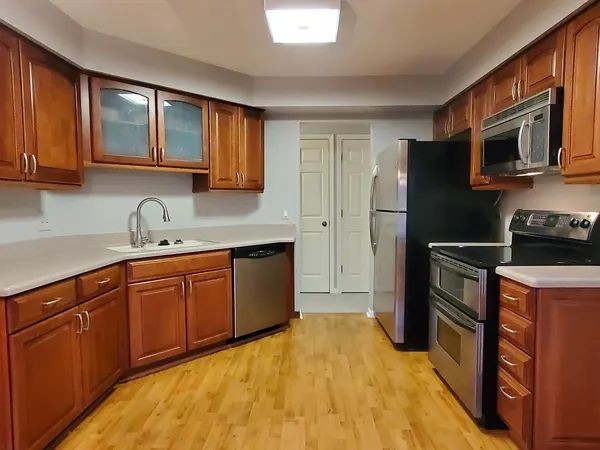 a kitchen with stainless steel appliances granite countertop a stove refrigerator sink and cabinets