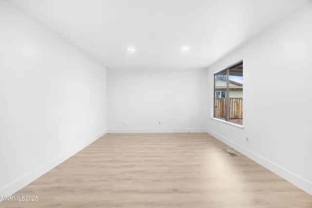 an empty room with a workspace and mirror