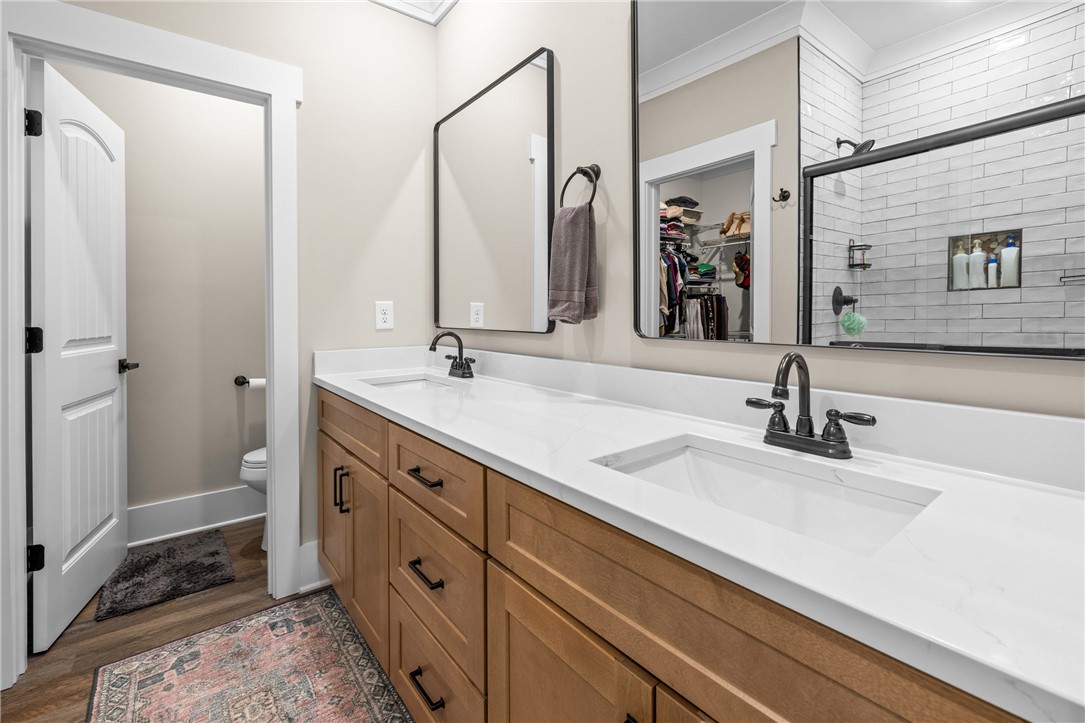 322 Thompson Street Pendleton, SC 29670 - Photo 27 of 38 A dual sink vanity with stone counters complements the modern tiled walk-in shower.