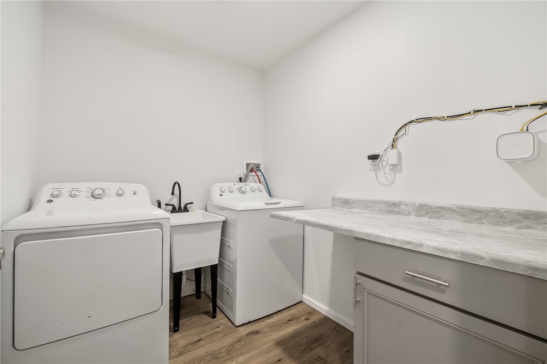 4392 Rio Verde Drive Fort Mohave, AZ 86426 - Photo 16 of 19 Dedicated laundry room featuring wood-finish flooring, a utility sink with a matte black faucet, and a grey cabinet with a light-toned countertop