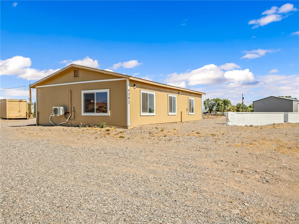 4392 Rio Verde Drive Fort Mohave, AZ 86426 - Photo 18 of 19 Single-story structure with a tan exterior, white trim windows, and a gravel lot