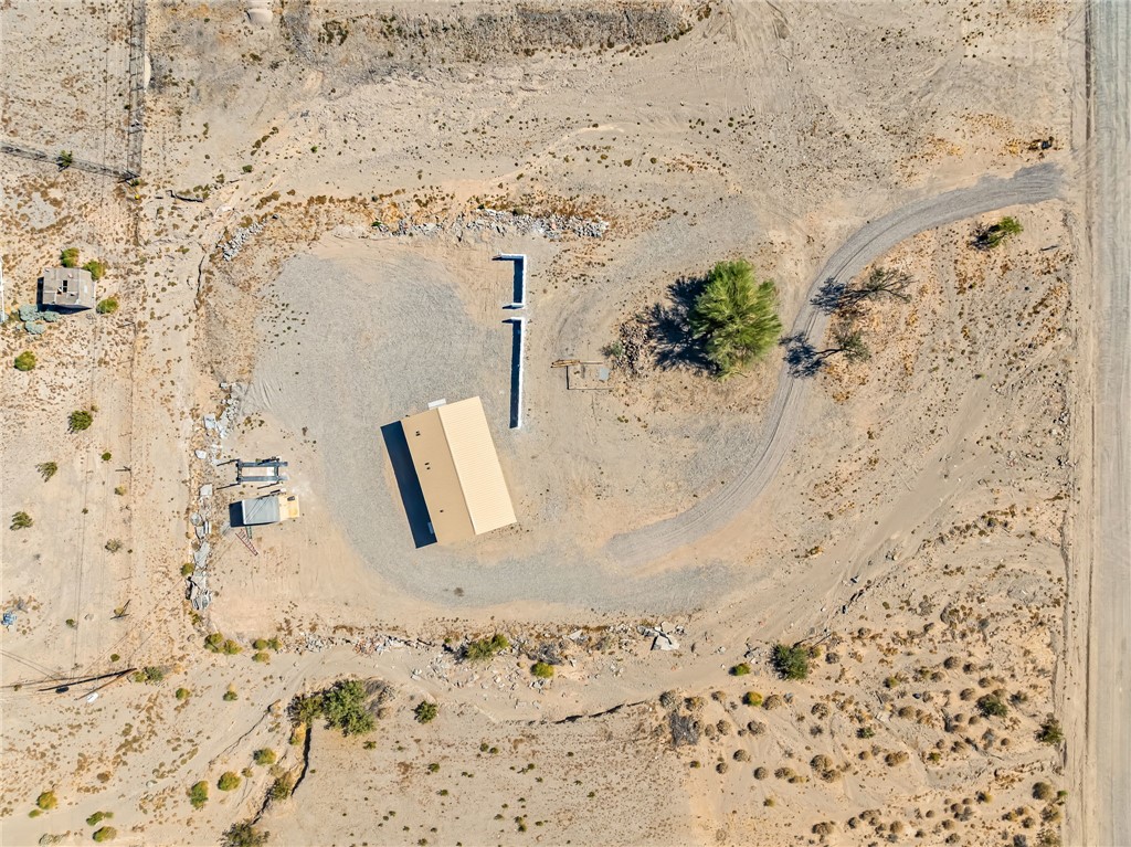 4392 Rio Verde Drive Fort Mohave, AZ 86426 - Photo 2 of 19 Expansive desert lot featuring a central building with a light-colored roof, a gravel-surfaced drive, and several mature trees