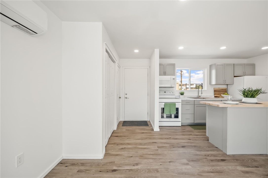 4392 Rio Verde Drive Fort Mohave, AZ 86426 - Photo 5 of 19 Open-concept living area featuring a kitchen with light gray cabinetry, white appliances, and a light wood-finish countertop on the island