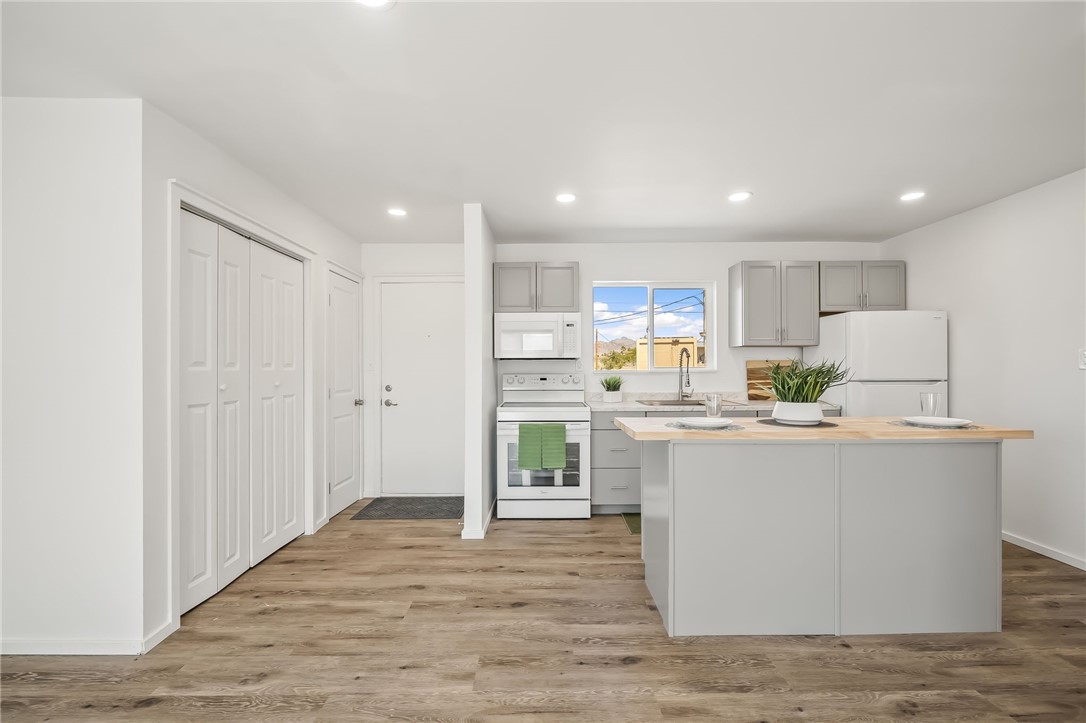 4392 Rio Verde Drive Fort Mohave, AZ 86426 - Photo 6 of 19 Modern kitchen featuring light gray cabinetry, white appliances, and a central island with a wood-finish countertop