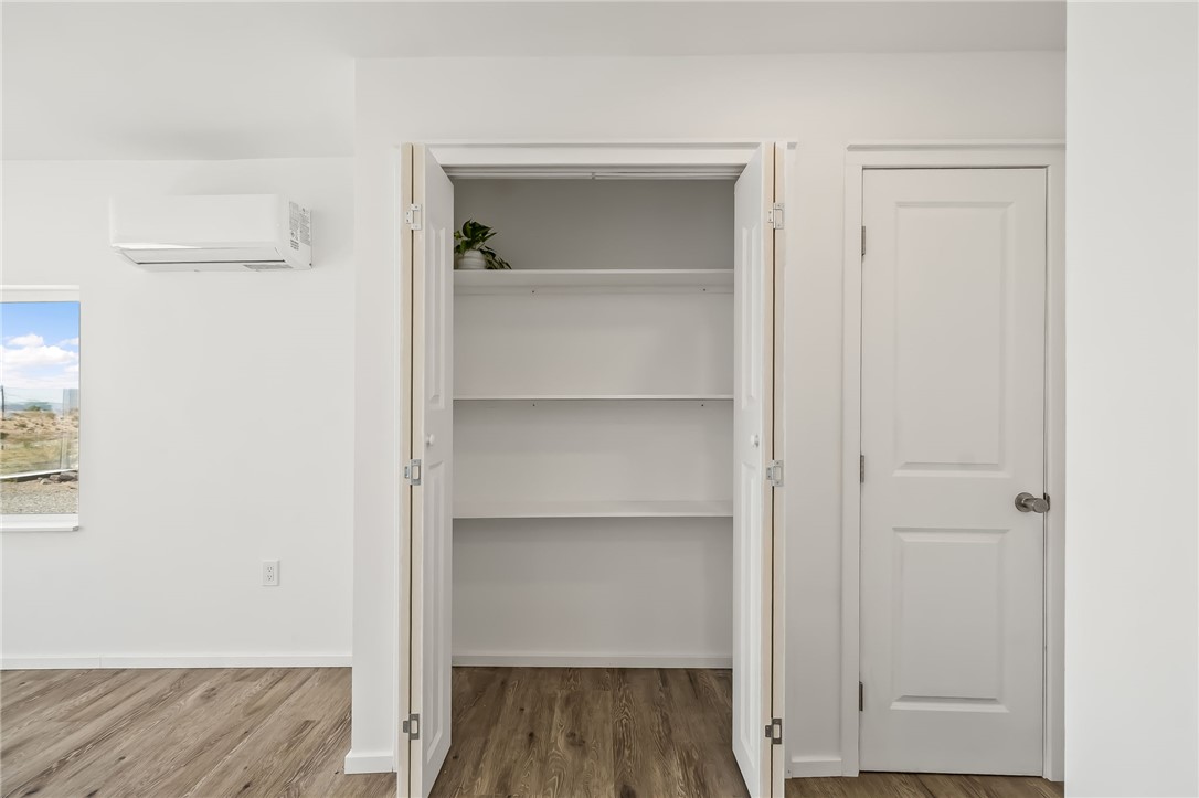 4392 Rio Verde Drive Fort Mohave, AZ 86426 - Photo 9 of 19 Interior storage closet featuring multiple white shelves, wood-finish flooring, white walls, and white trim