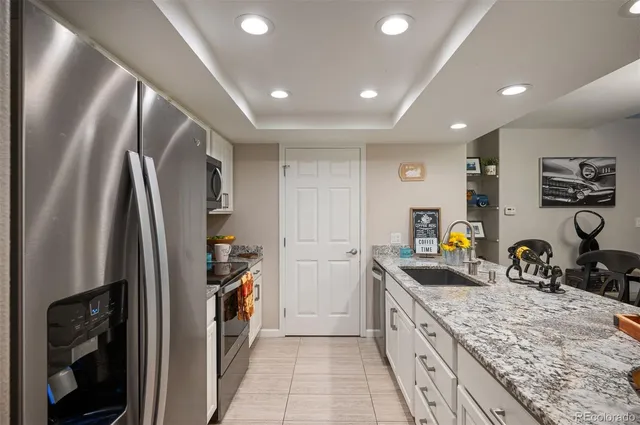 a kitchen with stainless steel appliances granite countertop a refrigerator and a sink